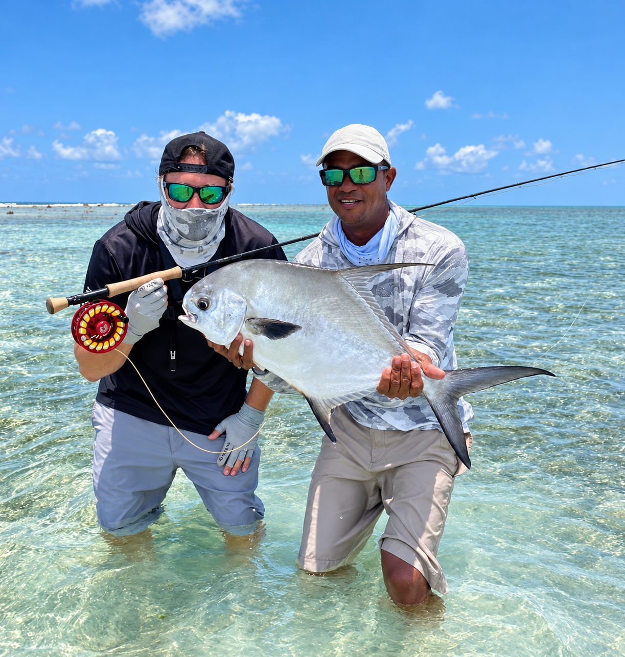 Jason Westby and an angler holding a fish on a shallow Belize flat