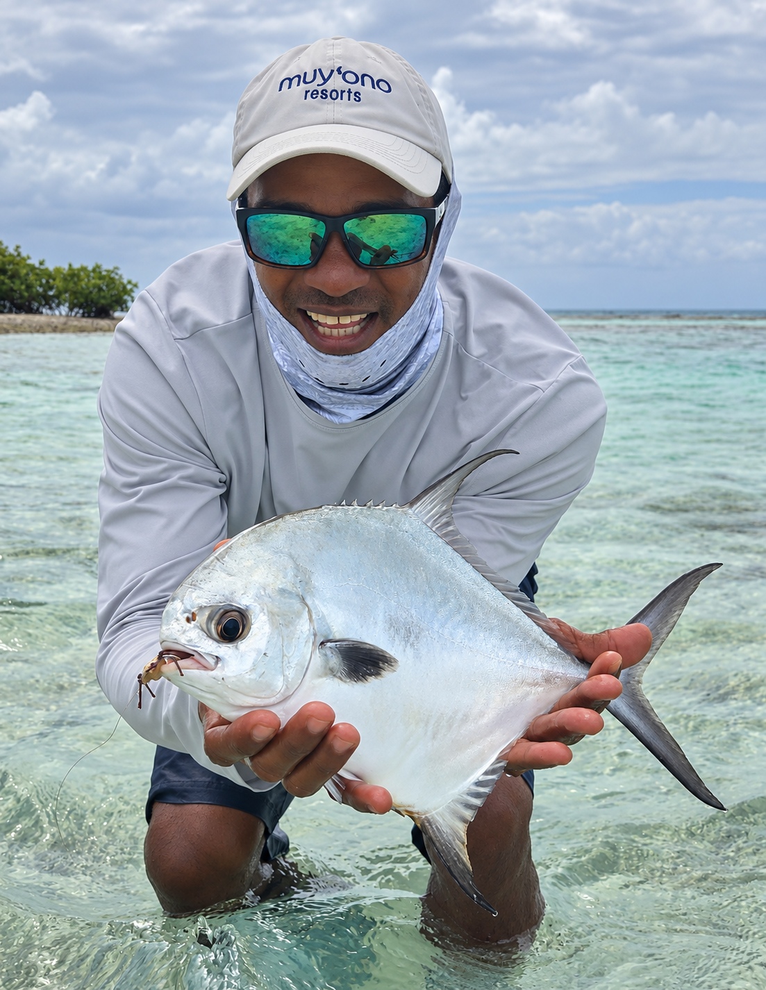 Jason Westby holding a fish in shallow water in Belize